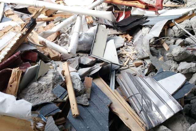 住宅の解体現場で発生する廃材の山。2026年は産廃処分費が高騰しており、これらが工事費を押し上げる要因になっている。