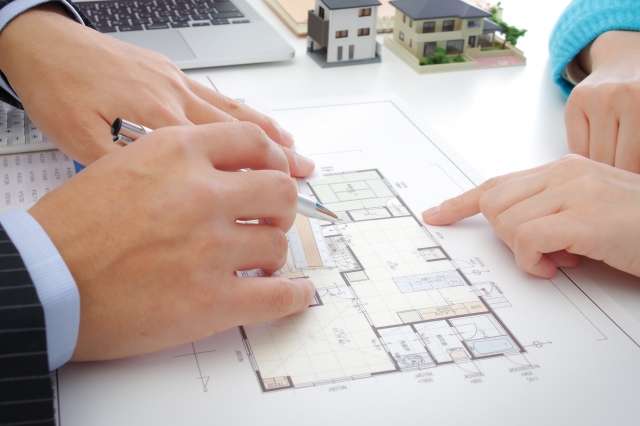 施主の希望に寄り添い、断熱性能とコスト、使い勝手のバランスを調整しながら窓を選ぶ設計士の打ち合わせイメージ。