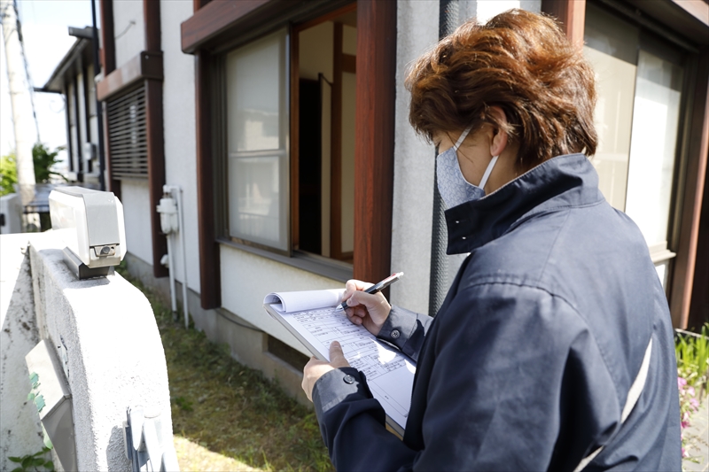 地震後に住宅の外部を確認している様子のイメージ写真