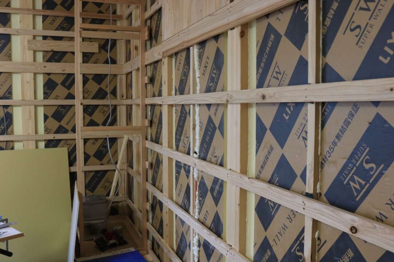 リフォーム現場での胴縁下地の施工例。古い柱の歪みを調整するために木材を流している様子