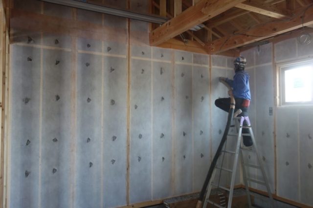 壁内に吹き込まれるセルロースファイバーの施工風景