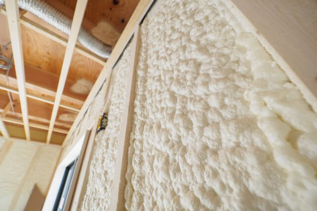 吹き付けウレタンフォーム断熱材の施工断面。柱間に発泡して隙間なく充填されている様子
